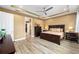 Open main bedroom featuring tray ceilings, a ceiling fan, and wood flooring at 9276 Sw 89Th St Rd, Ocala, FL 34481