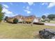 Well-maintained home exterior with lush green lawn, decorative shrubbery, and a two-car garage at 9285 Sw 90Th St, Ocala, FL 34481