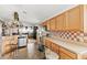 Kitchen featuring light wood cabinets, stainless steel appliances, and a view into the dining area at 9285 Sw 90Th St, Ocala, FL 34481