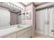 Well-lit bathroom with vanity, large mirror, and shower with a patterned curtain at 9884 Se 175Th Pl, Summerfield, FL 34491