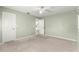 Bright bedroom featuring neutral carpet, ceiling fan, and a doorway leading to other rooms at 9884 Se 175Th Pl, Summerfield, FL 34491