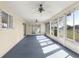 Enclosed sunroom with blue carpet and a ceiling fan at 9884 Se 175Th Pl, Summerfield, FL 34491