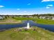 Scenic aerial view of a community water feature and lighthouse surrounded by lush green spaces, creating a peaceful ambiance at 9884 Se 175Th Pl, Summerfield, FL 34491