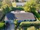 A high-angle aerial view of the home with a dark roof, mature trees, and manicured landscaping at 10958 Sw 86Th Ct, Ocala, FL 34481