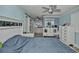This bedroom features a large bed, wood-look floors, blue walls, a ceiling fan, and an ensuite bath at 10958 Sw 86Th Ct, Ocala, FL 34481