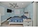 This bedroom features a large bed, wood-look floors, blue walls, a ceiling fan, and a shuttered window at 10958 Sw 86Th Ct, Ocala, FL 34481