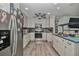 Bright kitchen boasts stainless steel appliances, granite countertops, light cabinets and hardwood floors at 10958 Sw 86Th Ct, Ocala, FL 34481