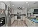 Bright kitchen boasts stainless steel appliances, granite countertops, light cabinets and hardwood floors at 10958 Sw 86Th Ct, Ocala, FL 34481