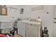 Functional laundry area with a washer, dryer, storage baskets, and overhead shelving at 10958 Sw 86Th Ct, Ocala, FL 34481