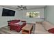 A spacious living room with hardwood floors, large windows, neutral walls, and comfortable seating at 10958 Sw 86Th Ct, Ocala, FL 34481