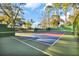 Outdoor pickleball court with vibrant colors, surrounded by fencing and trees for a private playing experience at 10958 Sw 86Th Ct, Ocala, FL 34481