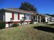 Charming single-story home with a well-maintained lawn and colorful accents on the shutters and trim at 11353 Sw 138Th Ln, Dunnellon, FL 34432
