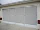 Exterior close-up of the modern garage door with multiple screened window panels, providing ventilation and sunlight at 11353 Sw 138Th Ln, Dunnellon, FL 34432