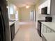 Open kitchen showcasing white cabinets, black appliances, and dining area beyond at 11353 Sw 138Th Ln, Dunnellon, FL 34432