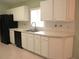 Spacious kitchen with white cabinetry, black appliances, and a large window at 11353 Sw 138Th Ln, Dunnellon, FL 34432