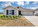 Charming single-story home featuring neutral stucco, black shutters, well-kept lawn, and two-car garage at 1157 Saguaro St, Haines City, FL 33844