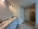 Bright bathroom with double vanity sinks, modern fixtures, and a separate tiled shower at 120 Dogwood Drive Cir, Ocala, FL 34472