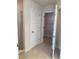 Bathroom with tiled walk-in shower, white door, tile floor and shelving in the walk in closet at 120 Dogwood Drive Cir, Ocala, FL 34472