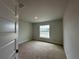 This bedroom features a neutral color scheme, window views and carpeted flooring at 120 Dogwood Drive Cir, Ocala, FL 34472
