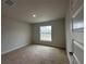 Bright bedroom featuring a neutral color scheme, carpeted flooring and a window at 120 Dogwood Drive Cir, Ocala, FL 34472