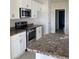 Kitchen featuring white cabinets, stainless steel appliances, and granite countertops, and a large island at 120 Dogwood Drive Cir, Ocala, FL 34472