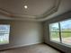 Serene bedroom with tray ceilings, large windows, and plush carpeting, creating a cozy retreat at 120 Dogwood Drive Cir, Ocala, FL 34472