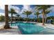 Community swimming pool surrounded by palm trees, lounge chairs, and clear blue water at 1229 Hillcrest View Loop, Apopka, FL 32703