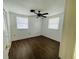 A bright bedroom features wood flooring, a ceiling fan and two windows providing plenty of light at 15040 Sw 29Th St, Ocala, FL 34481