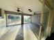 Bright sunroom with gray wood-look flooring, ceiling fans, and sliding glass doors to a large backyard at 15040 Sw 29Th St, Ocala, FL 34481