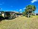 Landscaped backyard featuring a screened lanai and tropical palm trees at 16191 Sw 12Th Ter, Ocala, FL 34473