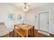 Cozy dining area with wooden table, bench, and chairs beneath a ceiling fan, adjacent to the kitchen at 1731 Se Clatter Bridge Rd, Ocala, FL 34471