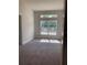 A bright bedroom with neutral walls, carpet flooring, and a large window allowing natural light at 2 Dogwood Crse, Ocala, FL 34472