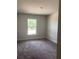 A view of a bedroom with plush carpet, neutral walls, and a bright window offering natural light at 2 Dogwood Crse, Ocala, FL 34472