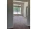 Spacious dining room with carpet, natural light from a large window, and an elegant chandelier at 2 Dogwood Crse, Ocala, FL 34472