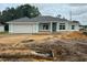 New home exterior with attached garage, light blue paint, and gray shingles on a cloudy day at 2 Dogwood Crse, Ocala, FL 34472