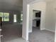 Open floor plan living room leading into the kitchen with dark cabinetry and natural lighting at 2 Dogwood Crse, Ocala, FL 34472