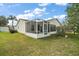 Spacious backyard view features a screened lanai, green lawn, and mature landscaping at 2538 Privada Dr, The Villages, FL 32162