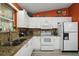 Bright kitchen features white cabinetry, granite countertops and modern appliances, perfect for culinary enthusiasts at 2538 Privada Dr, The Villages, FL 32162