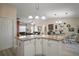 Open kitchen with granite countertop island overlooks the living and dining areas, creating a social hub at 2538 Privada Dr, The Villages, FL 32162