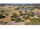 An aerial view of the property showcasing lush landscaping, a pond, and equestrian facilities nearby at 2775 Sw 53Rd St, Ocala, FL 34471