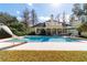 A picturesque backyard pool with a water slide, bordered by mature trees, offering a serene retreat at 2775 Sw 53Rd St, Ocala, FL 34471