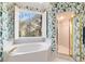 Bathroom featuring a soaking tub, shower, and a large window with scenic outdoor views at 2775 Sw 53Rd St, Ocala, FL 34471