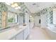 Spacious bathroom with floral wallpaper, double sinks, and a large soaking tub at 2775 Sw 53Rd St, Ocala, FL 34471