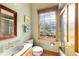 Cozy half bath featuring charming wallpaper, a wood framed mirror, and window with a view at 2775 Sw 53Rd St, Ocala, FL 34471