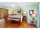 Charming bedroom featuring hardwood floors, four-poster bed, and light green walls at 2775 Sw 53Rd St, Ocala, FL 34471