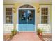 Charming entryway with striking blue-green double doors, decorative windows, and elegant sconces, framed by potted plants at 2775 Sw 53Rd St, Ocala, FL 34471