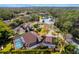 Aerial view of a home featuring a screened-in pool, backyard pond, and lush landscaping at 32 Allenwood Look, Ormond Beach, FL 32174