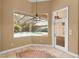 Cozy breakfast nook overlooking the screened-in pool with custom tile and an ornate hanging lamp at 32 Allenwood Look, Ormond Beach, FL 32174