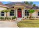 Inviting front entrance featuring a red door, decorative columns, and lush landscaping at 32 Allenwood Look, Ormond Beach, FL 32174