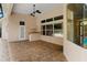 Covered lanai featuring brick pavers, ceiling fans, and a pass-through bar to the outdoor pool area at 32 Allenwood Look, Ormond Beach, FL 32174